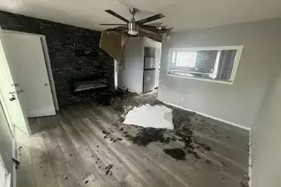 Fallen ceiling material on a wet living room floor after a leak