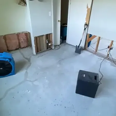 Technician reading moisture beside drying equipment in a Clearwater home