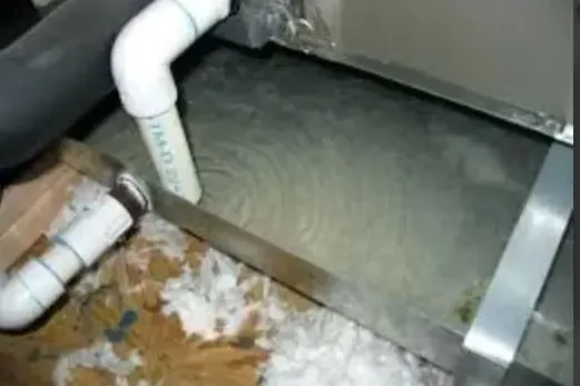 Ceiling stain spreading under an overflowing attic AC condensate pan