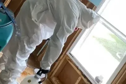 Technician in protective gear cleaning up a sewage backup