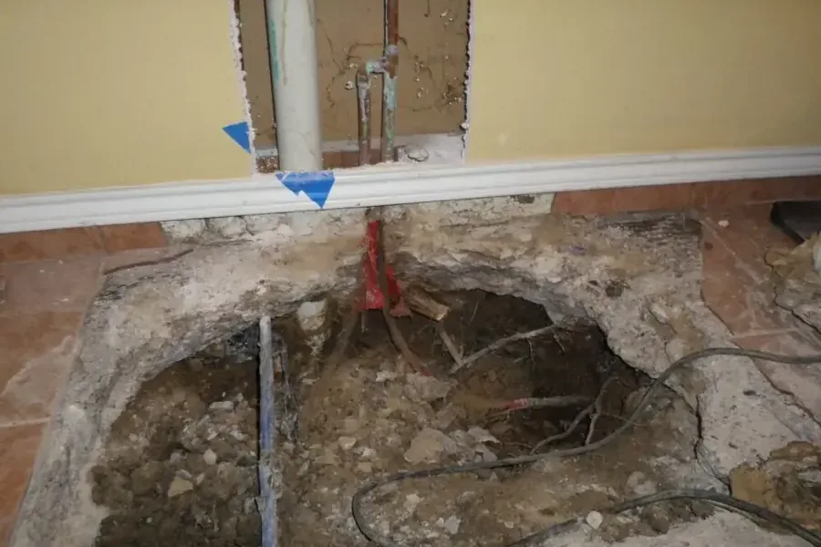 Concrete slab cut open to reach a leaking supply pipe under a home