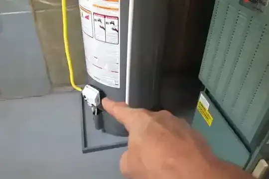 Leaking tank water heater being checked in a garage